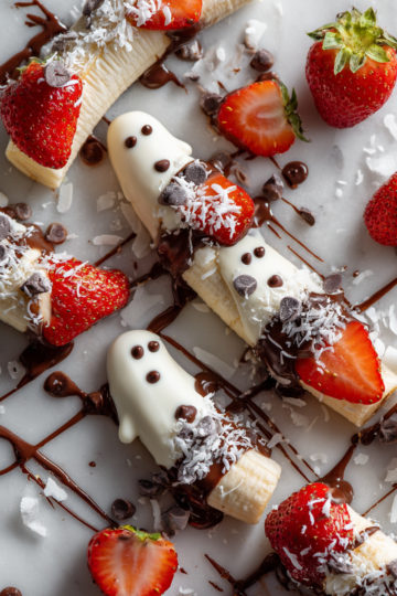 Divertenti Spiedini di Frutta Fantasma per Halloween Deliziosi spiedini di frutta fantasma decorati con cioccolato bianco, perfetti per una festa di Halloween.